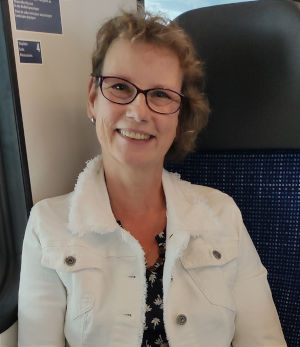Brigitte Krickl lächelnd an einer Wand
